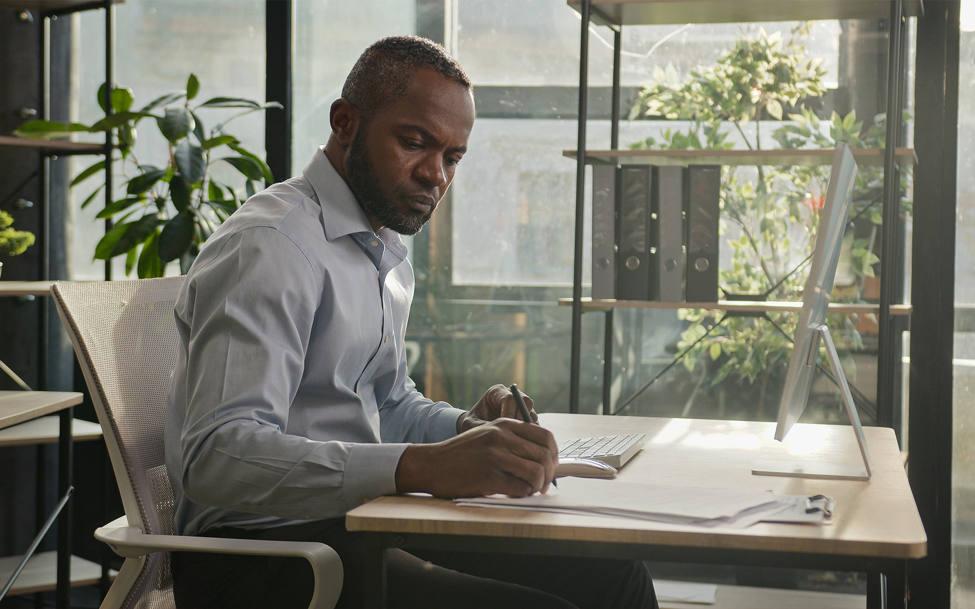 Side view of a man sitting in a well decorated office working on financial document